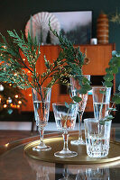 Sprigs of thuja, eucalyptus and juniper arranged in glasses of water