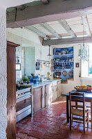 Rustikale Küche mit Holzbalken und Terrakotta-Fliesenboden