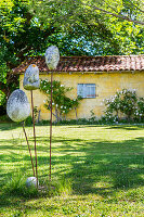 Steinskulptur im Garten, im Hintergrund Nebengebäude