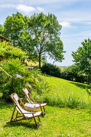 Zwei Liegestühle in sonnigem Garten