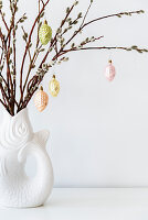 Pastel baubles hung from willow branches in fish-shaped vase
