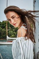 Brünette Frau im Sommerkleid auf einem Boot