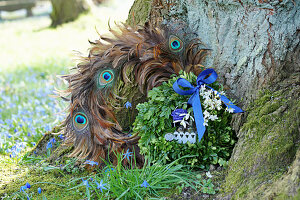 Buchskranz mit blauer Schleife und Blüten an Kranz aus Pfauenfedern