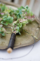 Hydrangea blossoms being tied into a wreath with wire