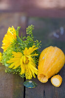 Ringelblumen und Fenchelblüten, Zierkürbis ausgehöhlt als Vase