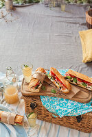 Italian style baguettes filled with mozzarella, prosciutto and tomato packed for picnic