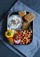 A breakfast box with muesli bars, stuffed snack peppers and chickpeas