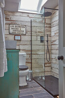 Duschbereich mit Keramik-Wandfliesen in Holzoptik im Badezimmer mit Dachflächenfenster