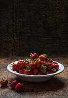 Bowl of fresh strawberries in a moody setting