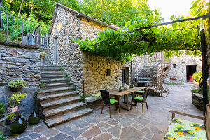 Terrace with natural stone tiles and overgrown pergola