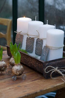 Four, white numbered pillar candles in rusty dish