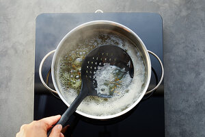 Legumes being cooked – foam being removed