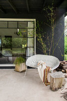 Rattan sofa, plant, and tree trunk stool on the terrace