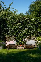 Rattan easy chairs with cushions in garden