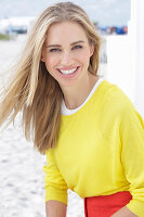 A long-haired blonde woman wearing a yellow top