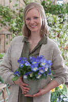 Woman with horned violet 'Blue Moon' in a zinc pot