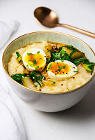 Breakfast Bowl mit Congee, Gemüse und Ei