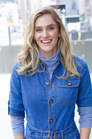 Junge blonde Frau in blauem Jeansoverall