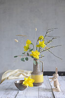 Minimalist spring bouquet with daffodils in a retro vase