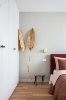 Palmenblätter als Deko neben dem Einbauschrank im Schlafzimmer