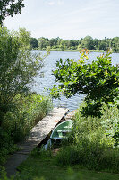 Blick auf Holzsteg und Boot am See