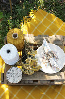 Thread spools, jam jar, flower, plate and napkin on wooden box