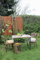 Garden table with birch bark decorations, two chairs and wooden box