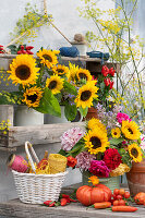 Bouquets of sunflowers, dahlias, roses and borage, edible ornamental peppers 'Salsa' in a pot, on the table tomatoes, yellow courgettes and basket with rolls of thread