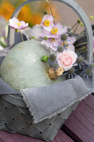 Gift basket with pumpkin 'Hungarian Blue', rose blossom, man litter and autumn anemones