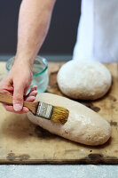 Brushing bread dough with water