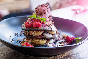 Verziertes rosa Dessert mit Himbeer- und Minzblättern