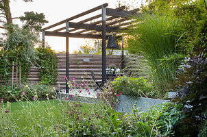 Blick auf Pergola in üppig bewachsenem Garten