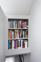 Wall of bookshelves above narrow staircase