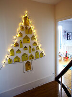 Full-size advent calendar in the shape of a Christmas tree on hallway wall of French family home