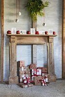 Christmas presents and baubles with salvaged wooden fireplace