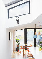 Blick durch eine moderne Küche mit Esstisch neben Flügeltüren und Oberlichtern London UK
