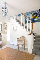 Staircase with striped runner, large picture and chandelier