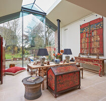 Living room with Asian-inspired furnishings and glass wall with view to the garden