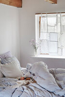 Bedroom with DIY curtain made from lace doilies and cushions with lace