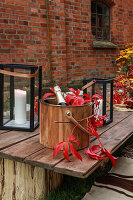 Champagne bucket decorated with red Virginia creeper on wooden table
