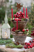 Tower of terracotta pots with ornamental apples and candles as Advent wreath