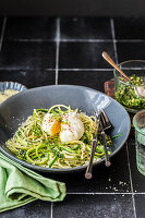 Spaghetti mit Zucchinistreifen, Grünkohlpesto, Parmesan, pochiertem Ei und Kresse-Microgreens