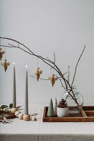 Table decoration in natural colors with candles, twigs and wooden tray