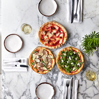 Different pizzas on marble table