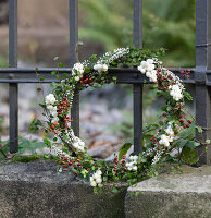 Wreath of snowberries, rosehips, heather and Mühlenbeckia on an old, nostalgic iron fence