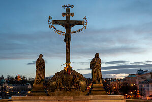 Christusfigur am Kreuz und zwei Heiligenfiguren, auf der Karlsbrücke bei Dämmerung, Prag, Tschechien