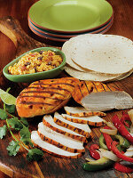Asada marinated chicken breasts grilled and served with roasted bell peppers and onions, tortillas and Spanish rice