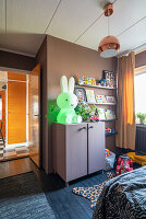 Hasenlampe auf halbhohem Schrank im Kinderzimmer mit schwarzem Dielenboden