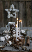 Four candle sticks in cinnamon sticks with larch twigs and cotton, coffee cup with deer motif