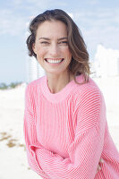 Happy, long-haired woman in pink jumper
